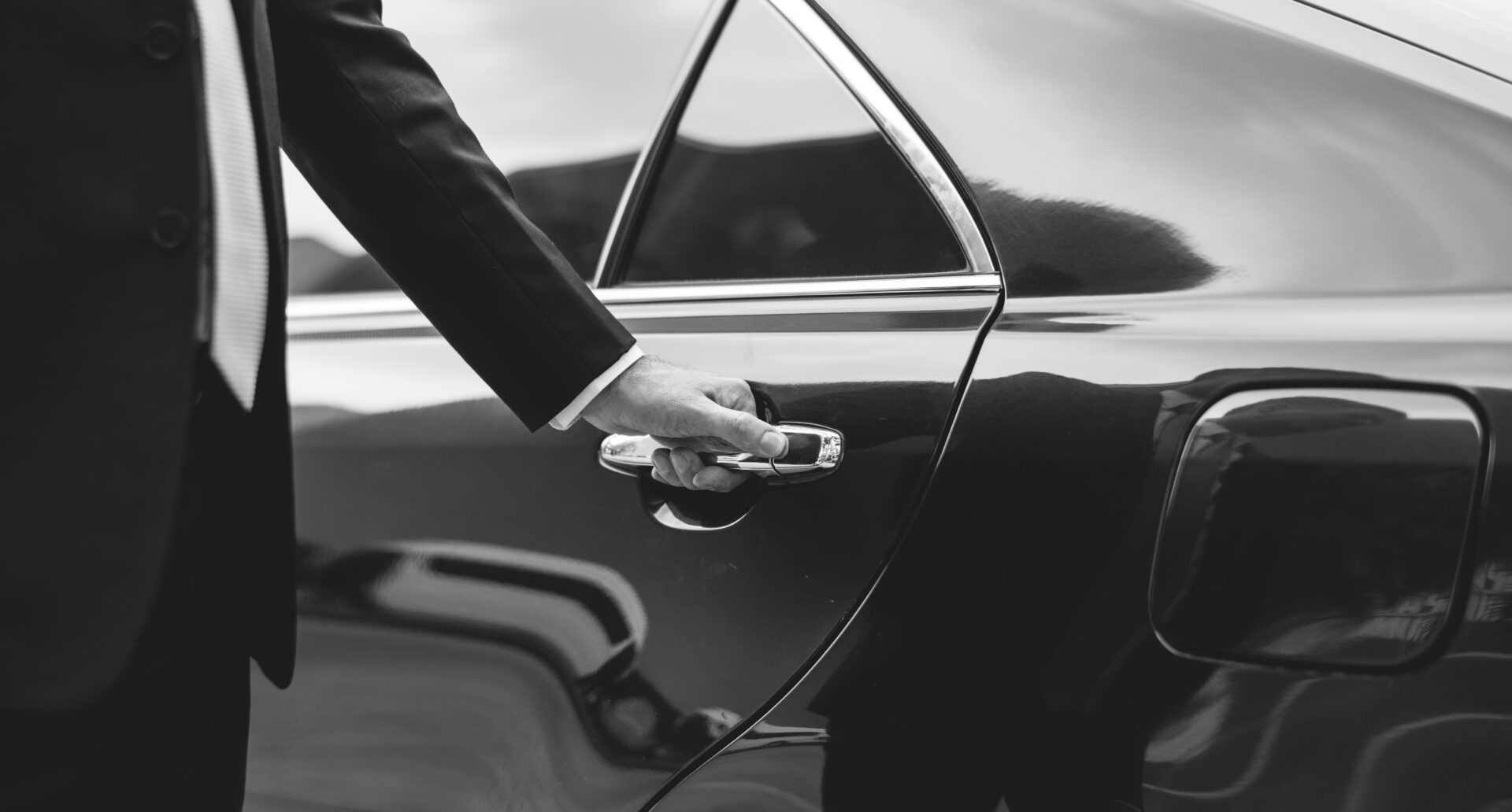 Professional chauffeur opening car door