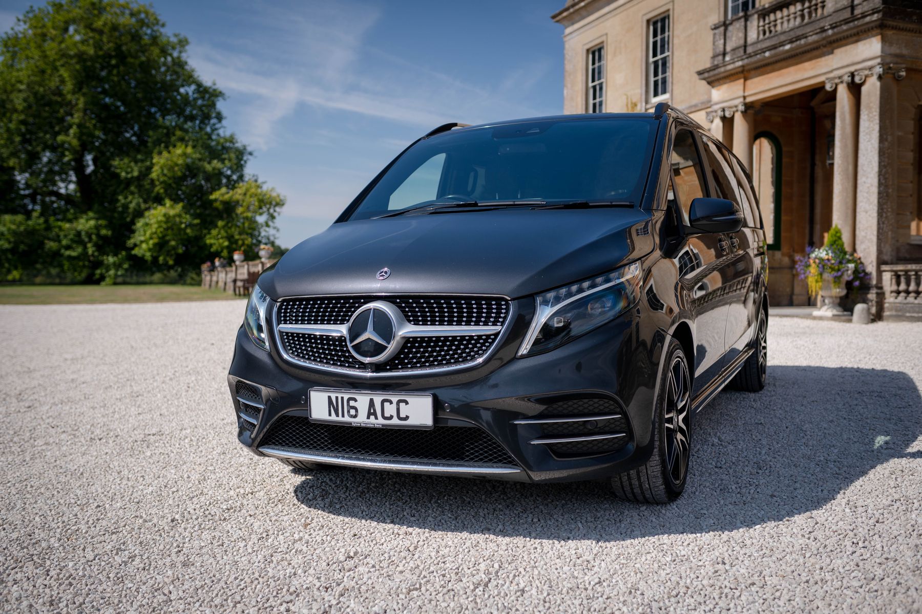 Black Mercedes V-Class outside a Bath-stone country house