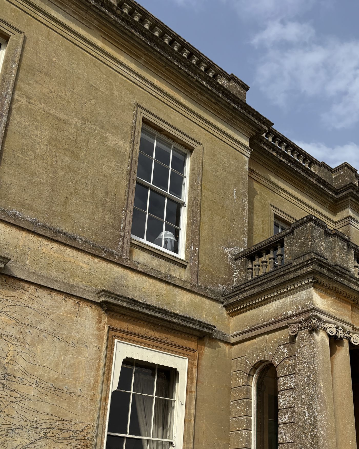 The columned portico and sash windows of a Georgian Bath-stone house